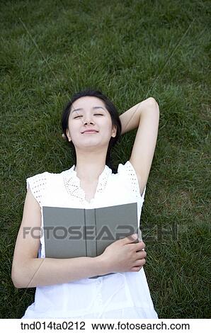 Stock Image - woman sleeping on the grass. Fotosearch