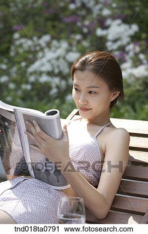 couple reading the magazine on the bench View Large Photo Image Stock Image - couple reading the magazine on the bench. Fotosearch