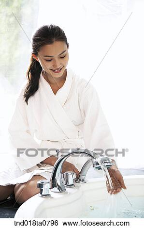 woman checking temperature of the water of the bath tub View Large Photo Image Stock Photograph - woman checking temperature of the water of the bath tub. Fotosearch