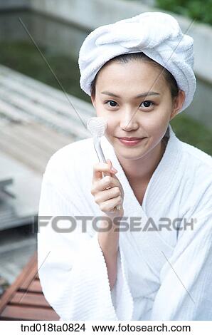 Picture - woman doing massage with her massage brush. Fotosearch