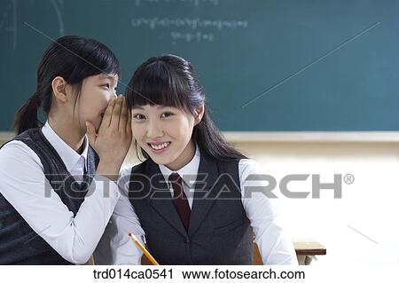 Stock Image - school uniform, classroom, education, daytime, Asian, secret. Fotosearch