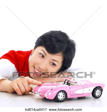 Stock Photo - stretching, object, Asian, model car, minicar, smile. Fotosearch