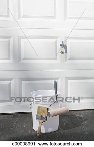 Paint Bucket Roller And Brush By Garage Door Stock Image