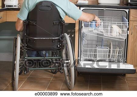 Man In Wheelchair Unloading Dishwasher Man In Wheelchair Unloading Dishwasher