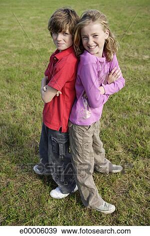 Boy and girl standing back to back Stock Photo | e00006039 | Fotosearch