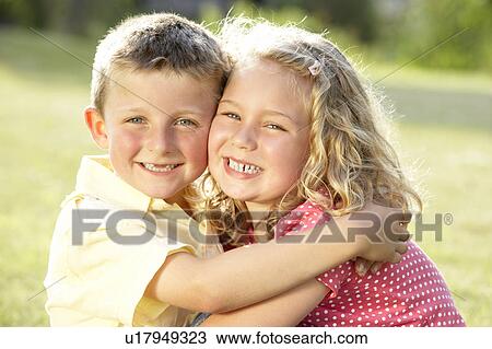 Stock Image - 2 Children hugging outdoors. Fotosearch
