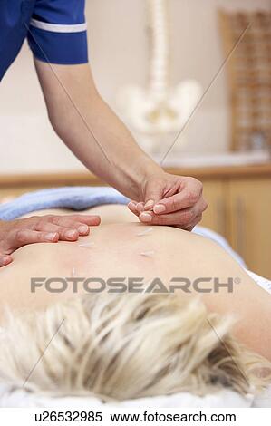Acupuncturist treating female client View Large Photo Image Stock Photography - Acupuncturist treating female client. Fotosearch