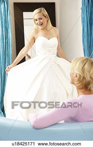 Bride trying on wedding dress with sales assistant View Large Photo Image Stock Image - Bride trying on wedding dress with sales assistant. Fotosearch