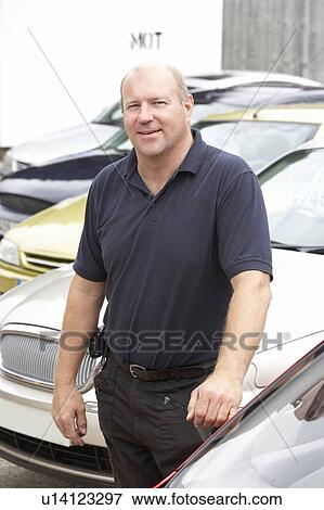 Car salesman standing on lot View Large Photo Image Stock Photo - Car salesman standing on lot. Fotosearch