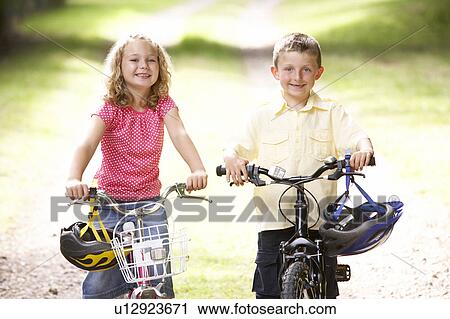 Stock Image - Children riding bikes in countryside. Fotosearch