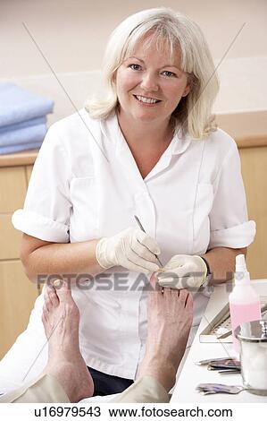 Chirpodist treating client in clinic View Large Photo Image Stock Image - Chirpodist treating client in clinic. Fotosearch
