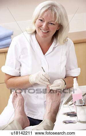 Stock Image - Chirpodist treating client in clinic. Fotosearch