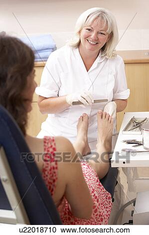 Stock Image - Chirpodist treating client in clinic. Fotosearch