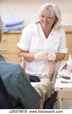 Chirpodist treating client in clinic View Large Photo Image Stock Photo - Chirpodist treating client in clinic. Fotosearch