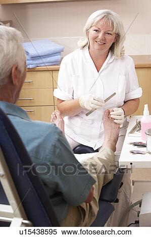 Chirpodist treating client in clinic View Large Photo Image Stock Photography - Chirpodist treating client in clinic. Fotosearch