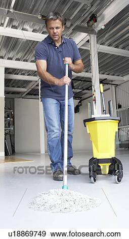Stock Photo - Cleaner mopping office floor. Fotosearch