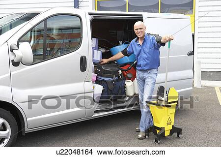 Picture - Cleaner standing next to van. Fotosearch