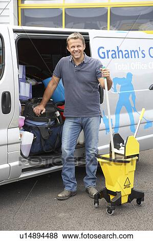 Stock Photo - Cleaner standing next to van. Fotosearch