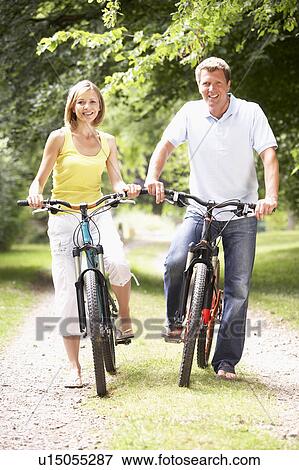 Couple riding bikes in countryside View Large Photo Image Stock Photo - Couple riding bikes in countryside. Fotosearch