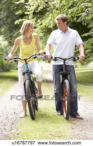 Couple riding bikes in countryside View Large Photo Image Stock Photo - Couple riding bikes in countryside. Fotosearch