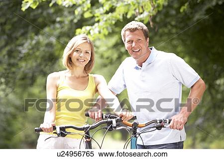 Stock Photography - Couple riding bikes in countryside. Fotosearch
