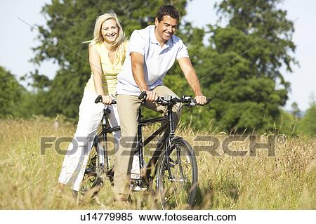 Couple riding tandem in countryside View Large Photo Image Stock Photography - Couple riding tandem in countryside. Fotosearch