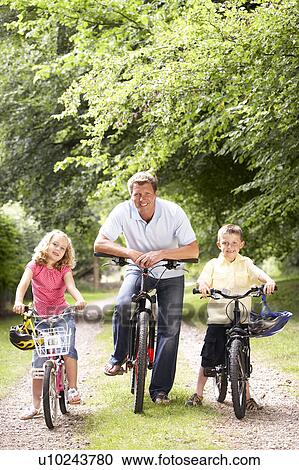 Father and children riding bikes in countryside View Large Photo Image Stock Image - Father and children riding bikes in countryside. Fotosearch