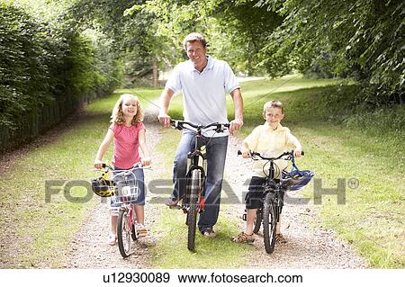 Father and children riding bikes in countryside View Large Photo Image Stock Photo - Father and children riding bikes in countryside. Fotosearch