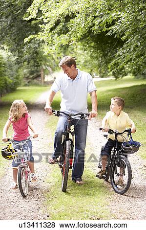 Father and children riding bikes in countryside View Large Photo Image Stock Photo - Father and children riding bikes in countryside. Fotosearch