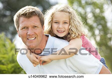 Stock Image - Father giving daughter piggyback. Fotosearch