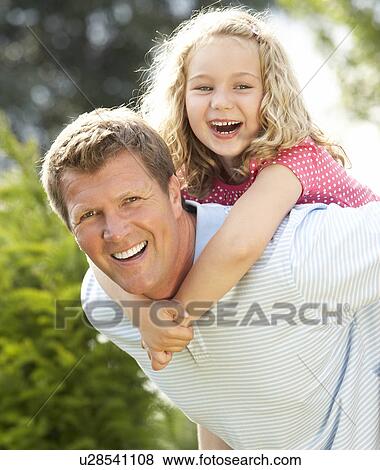 Stock Photo - Father giving daughter piggyback. Fotosearch