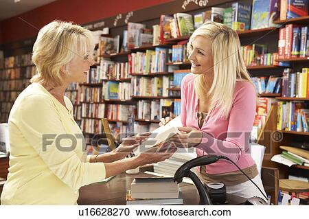 Stock Image - Female customer in bookshop. Fotosearch