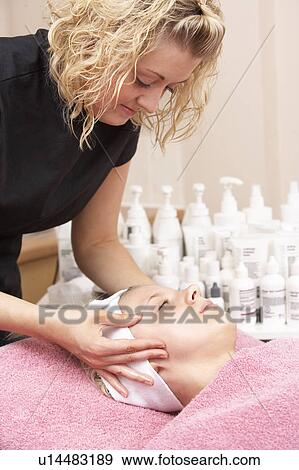 Stock Photo - Female masseuse giving client facial. Fotosearch