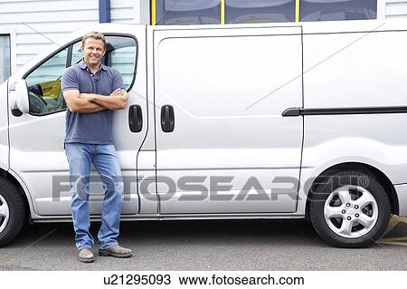 Stock Image - Man standing next to van. Fotosearch