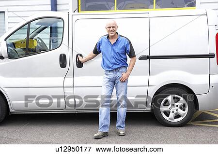 Stock Photo - Man standing next to van. Fotosearch