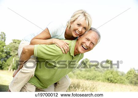 Stock Image - Mature couple having fun in countryside. Fotosearch