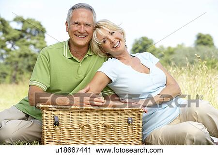 Mature couple having picnic in countryside View Large Photo Image Stock Image - Mature couple having picnic in countryside. Fotosearch
