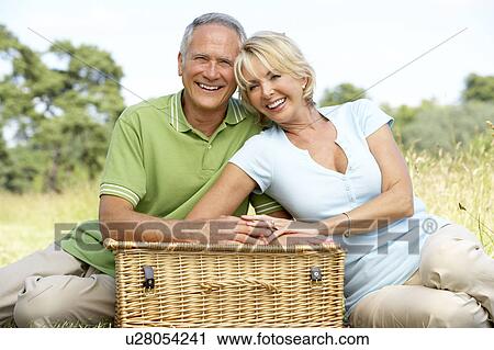 Mature couple having picnic in countryside View Large Photo Image Stock Image - Mature couple having picnic in countryside. Fotosearch