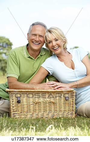 Stock Photo - Mature couple having picnic in countryside. Fotosearch