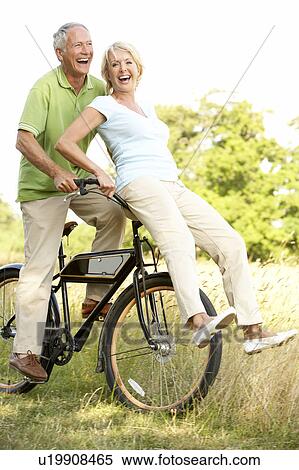 Mature couple riding bike in countryside View Large Photo Image Stock Photography - Mature couple riding bike in countryside. Fotosearch