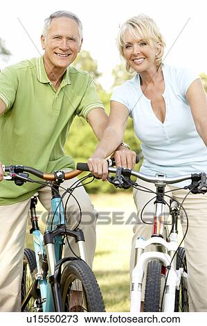 Mature couple riding bikes View Large Photo Image Stock Image - Mature couple riding bikes. Fotosearch