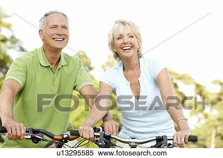 Mature couple riding bikes View Large Photo Image Stock Photography - Mature couple riding bikes. Fotosearch