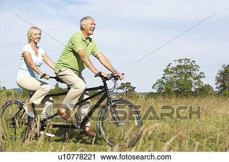 Mature couple riding tandem View Large Photo Image Stock Image - Mature couple riding tandem. Fotosearch