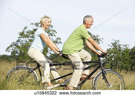 Mature couple riding tandem View Large Photo Image Stock Image - Mature couple riding tandem. Fotosearch