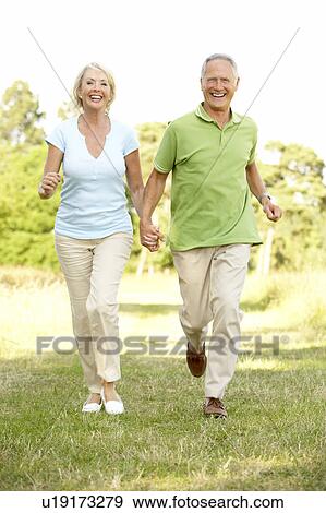 Mature couple walking in countryside View Large Photo Image Stock Photo - Mature couple walking in countryside. Fotosearch