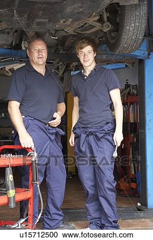 Mechanic and apprentice working on car View Large Photo Image Stock Image - Mechanic and apprentice working on car. Fotosearch