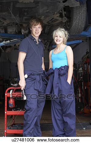 Stock Photograph - Mechanic and apprentice working on car. Fotosearch