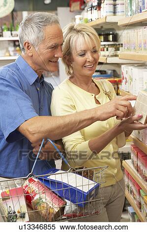 Middle aged couple buying herbal tea View Large Photo Image Stock Photography - Middle aged couple buying herbal tea. Fotosearch
