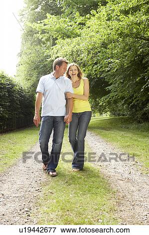 Middle aged couple walking in countryside View Large Photo Image Stock Photo - Middle aged couple walking in countryside. Fotosearch