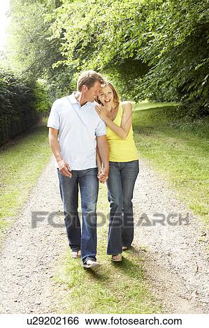 Stock Photograph - Middle aged couple walking in countryside. Fotosearch